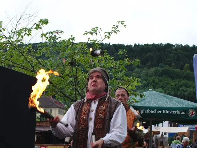 This image consists of tents and stalls in the middle. There is a person holding fire in the...