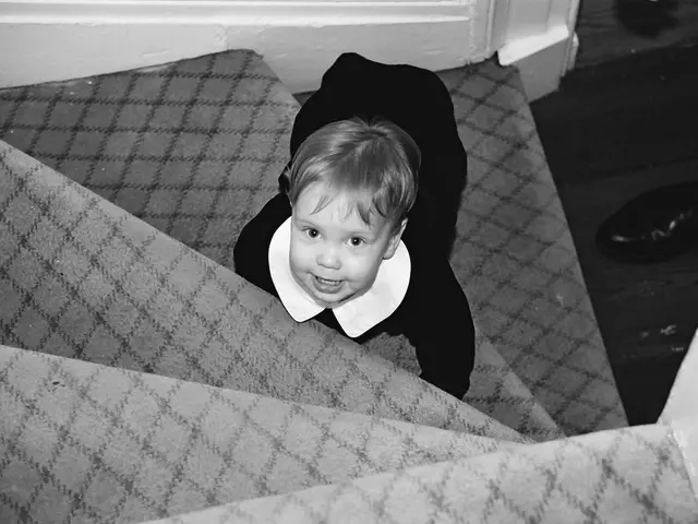 In this image I can see a child present on the stairs, there are shoes on the right. This is a...