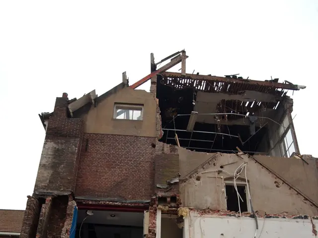 In the picture we can see a building which is collapsed and top of the picture there is clear sky.