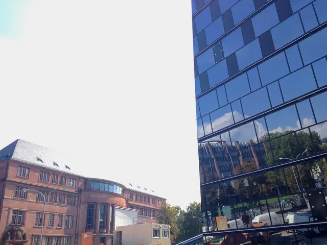 In the foreground of this image, on the right, there is a glass building. In the background, there...