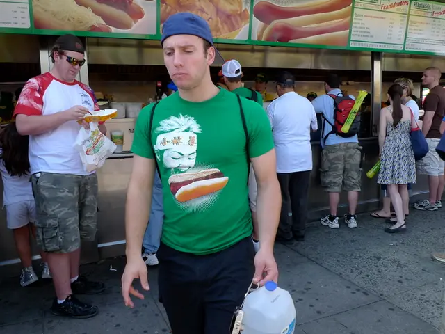 In this image I can see food court. In front of this many people standing on the floor. In the...