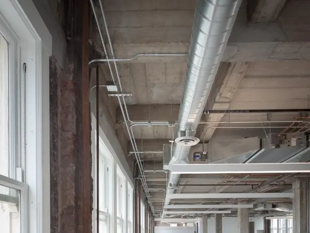 In this image we can see an inside view of a building and a pipe attached to the ceiling, there are...