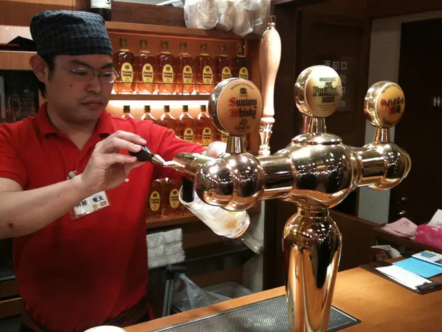 Here in this picture we can see a person filling a glass with beer with machine present in front of...