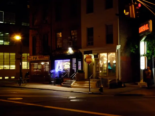 In this image we can see buildings, lights, stores, stairs, trees, road, bicycle and traffic...