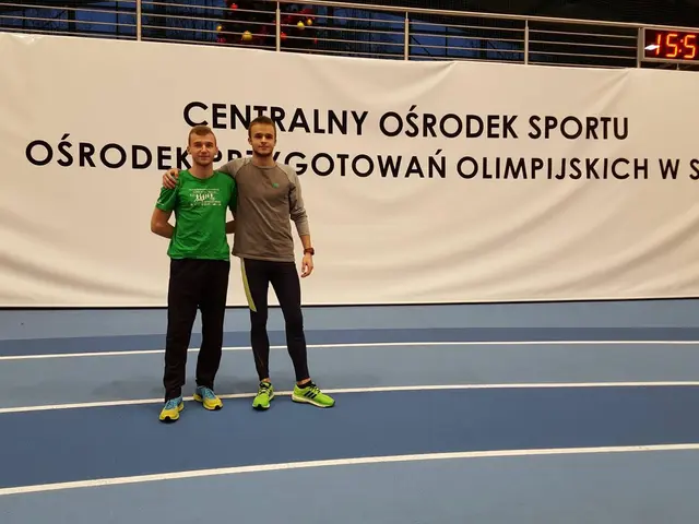 The image shows two men standing next to each other on a tennis court, with a banner in the...