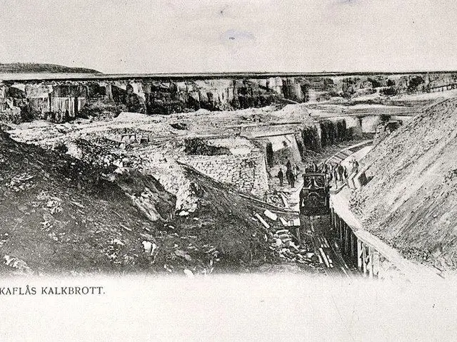 The image shows an old black and white photo of a train going through a tunnel, with a bridge in...