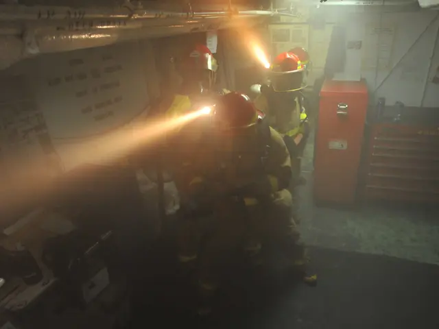 The image shows a group of firefighters wearing helmets and holding fire extinguishers in a room....