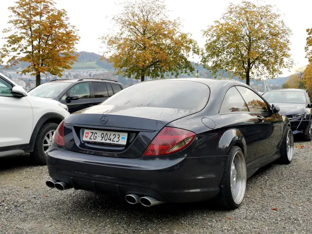 The image shows a black Mercedes Benz CLK parked in a parking lot next to other cars, with a number...
