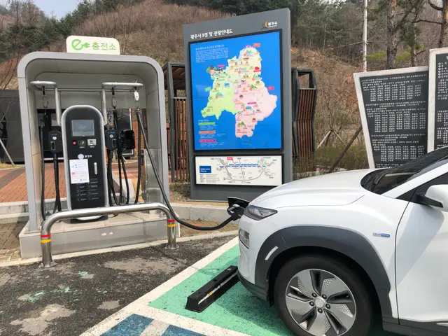 The image shows an electric car charging at a charging station in Seoul, South Korea. The station...