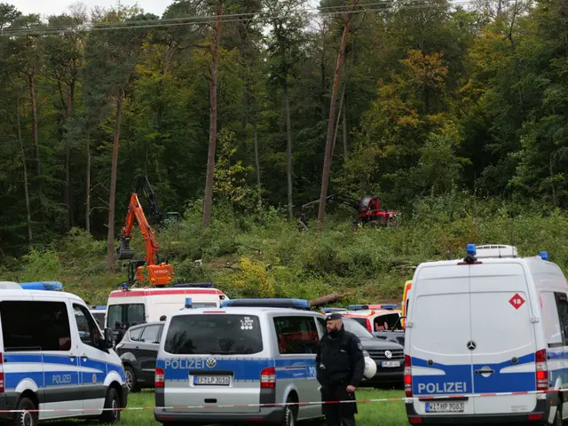 The image shows a group of police cars parked in a parking lot next to each other, with a person...