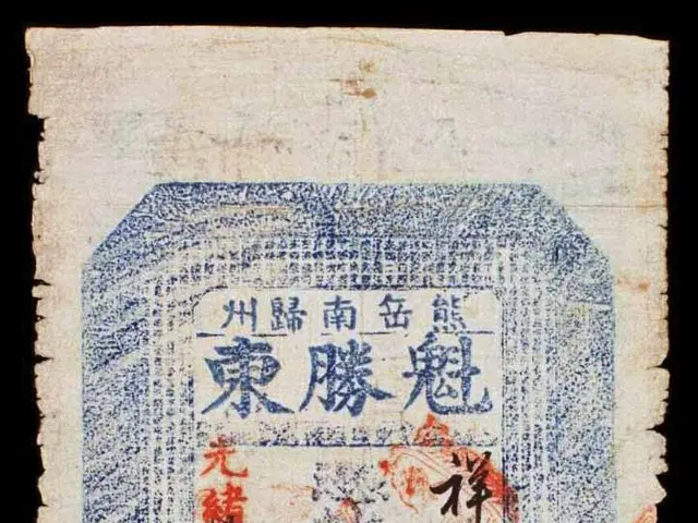 The image shows an old Japanese banknote with Chinese writing on it, set against a dark background....