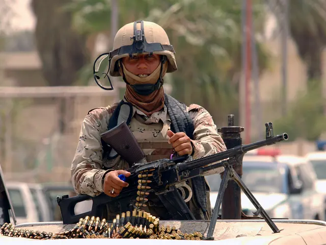 The image shows a soldier wearing a helmet and holding a machine gun on top of a truck, surrounded...