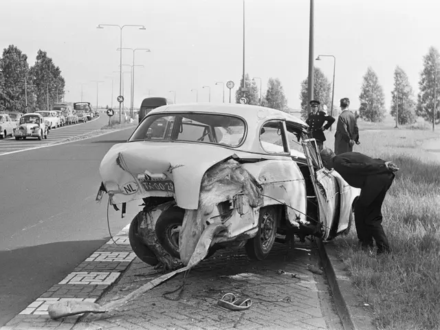 The image shows a black and white scene of a car that has been involved in a crash on the side of...