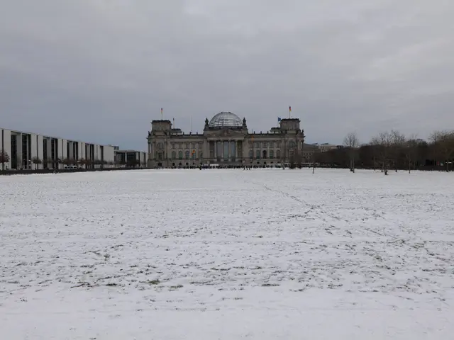 The image shows the Reichstag building in Berlin, Germany, covered in a blanket of snow. The...