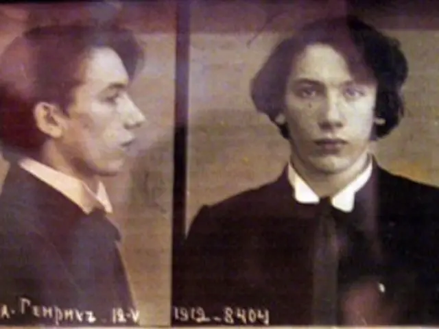 The image shows an old mug shot of a man in a suit and tie, with two pictures of him and some text...