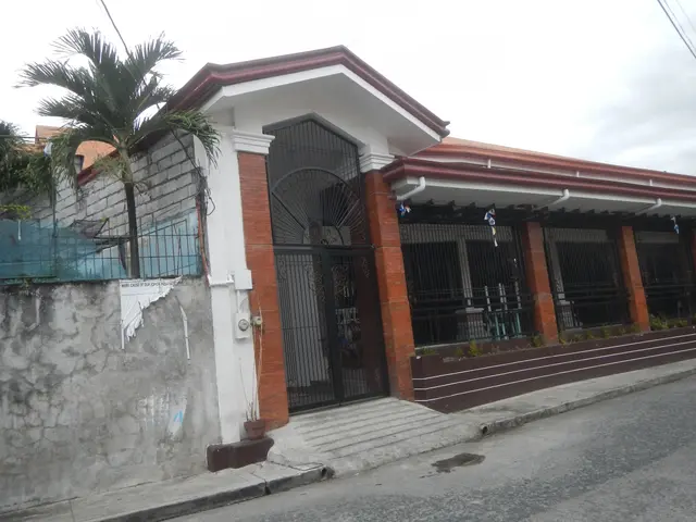 The image shows a house for sale in Imus, Cavite, Philippines. It has a roof, windows, a gate, a...