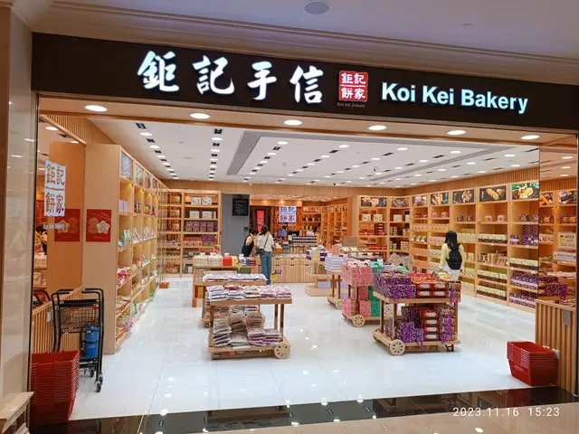 The image shows the inside of a store with a sign that reads "Koi Kei Bakery". There are people...