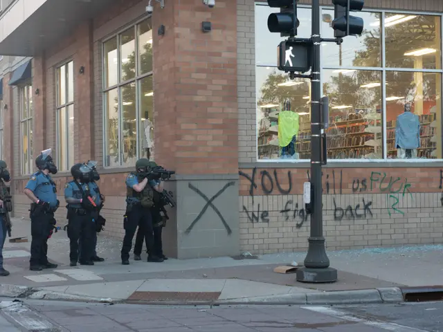 The image shows a group of police officers standing in front of a building with glass windows,...