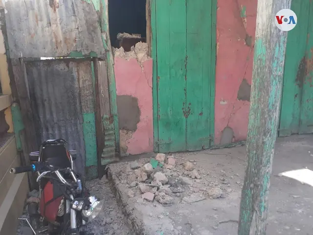 The image shows a motorcycle parked in front of a building with a green door, surrounded by stones...
