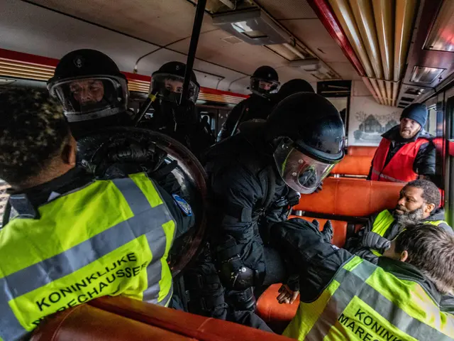 The image shows a group of police officers in riot gear on a bus, with some of them wearing helmets...