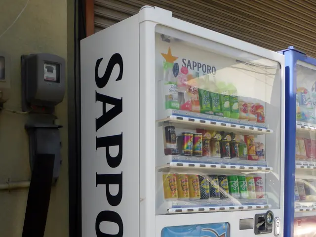The image shows a white and blue vending machine sitting on the side of a street. On the left side...