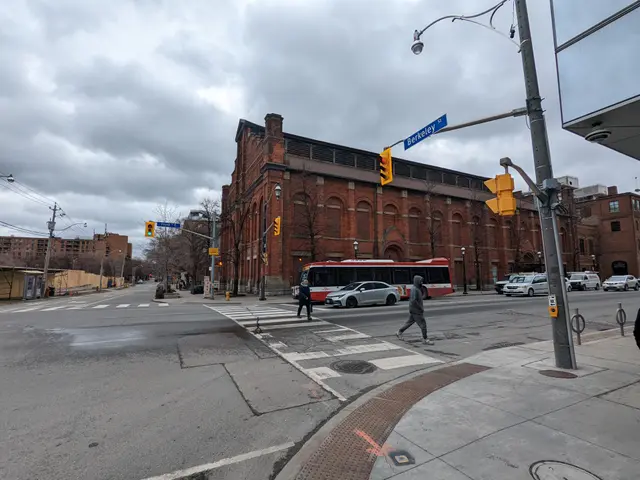 The image shows a city street with a bus stopped at a crosswalk. There are vehicles on the road,...