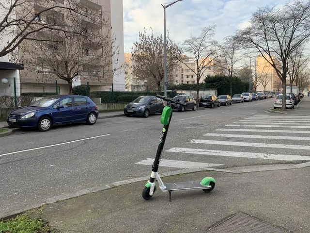 The image shows an electric scooter parked on the side of a street, surrounded by vehicles on the...