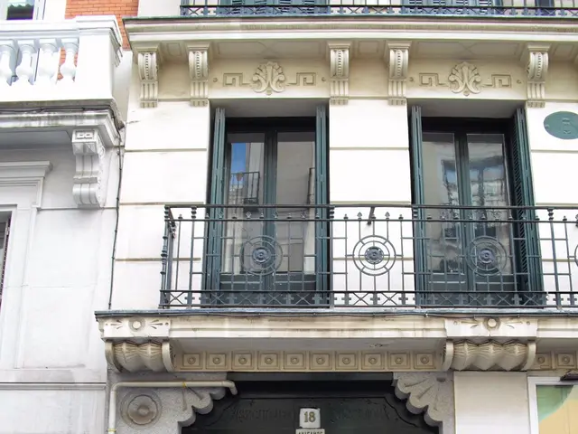 The image shows a building with a green door and windows on the side of it, along with railings,...