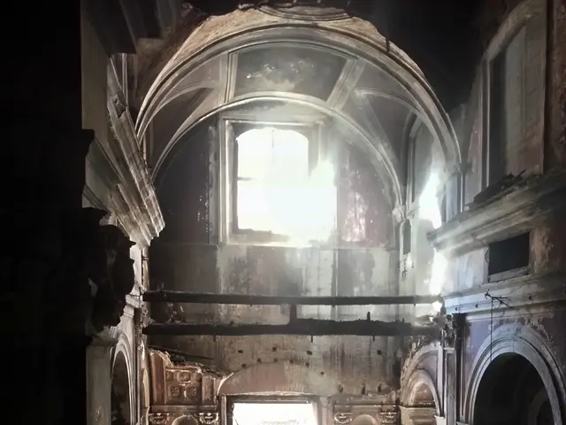 The image shows the interior of a building that has been destroyed by fire, with broken pieces of...