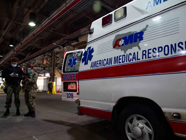 The image shows an American Medical Response (AMR) ambulance parked inside of a building, with two...