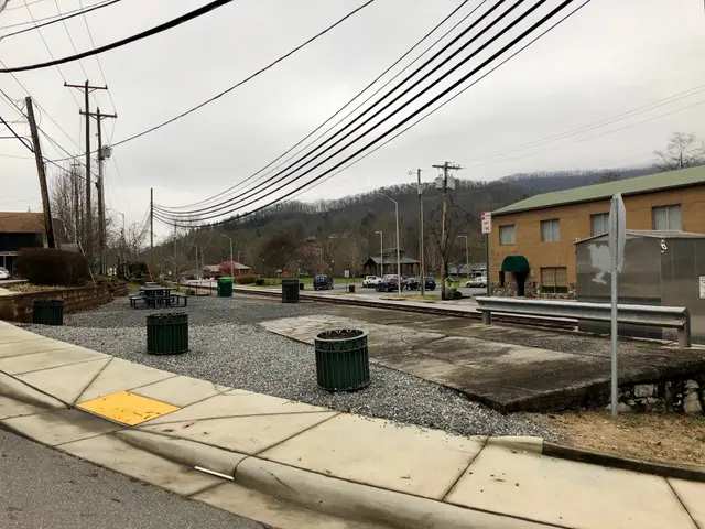 The image shows a city street with a sidewalk, trash cans, street light, trash bin/can, electric...