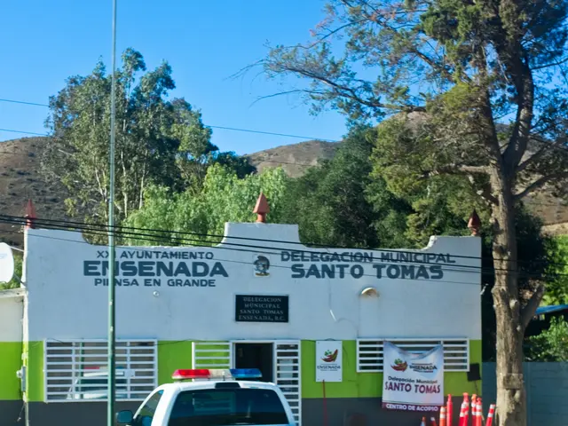 The image shows a police car parked in front of a building with a sign on it. The building has...