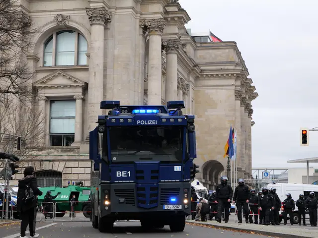 The image shows a group of police officers standing in front of a large building with windows,...