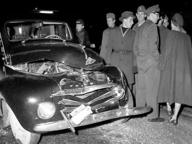 The image shows a black and white scene of a car that has been involved in a crash on the side of...