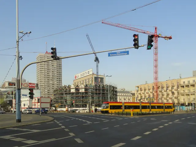 The image shows a city street with a yellow bus driving down it, surrounded by tall buildings with...