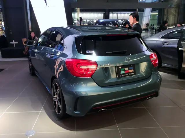 The image shows a Mercedes-Benz A-Class hatchback at the Frankfurt Motor Show, surrounded by a...