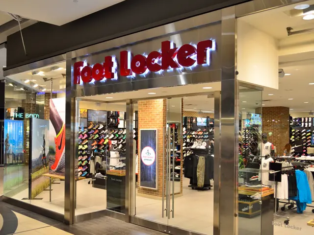The image shows a foot locker store in a shopping mall, with glass walls and doors, clothes hung on...