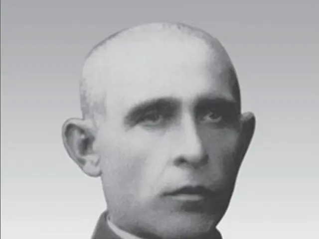 The image shows a black and white photo of a man in a priest's robes, with a white background. The...