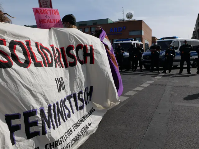 The image shows a group of people walking down a street, holding a banner that reads "Solidarity...