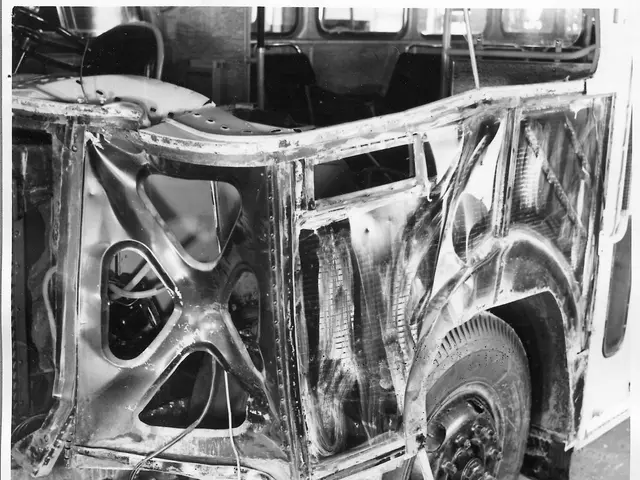 The image shows a black and white photo of a car that is in the process of being worked on, with...