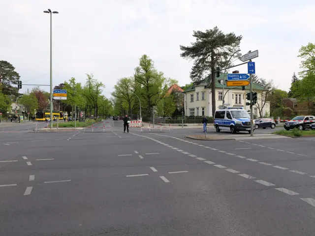 The image shows a roundabout with a police car parked on the side of the road. There are vehicles...