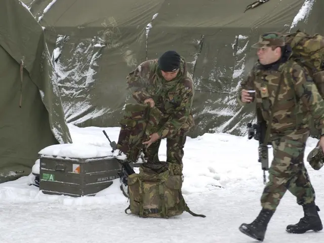 The image shows two men in camouflage walking through the snow next to a tent. They are both...