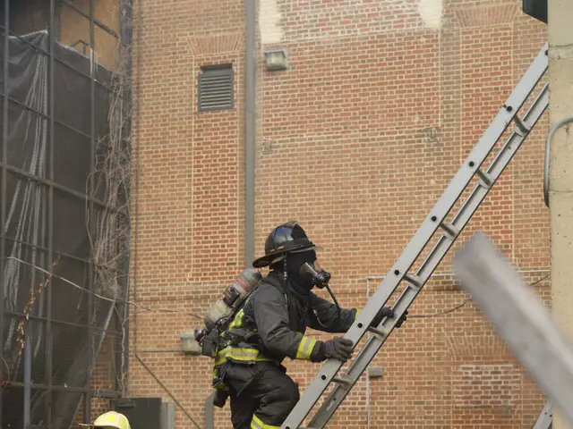 The image shows a group of firefighters wearing helmets and cylinders, climbing up a ladder in...