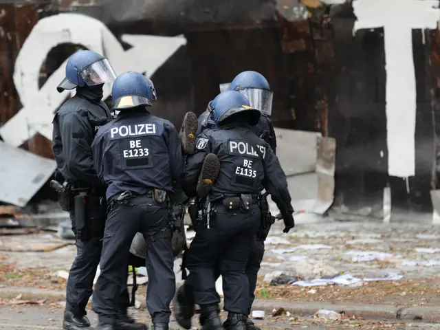 The image shows a group of police officers standing in front of a building with graffiti on it....