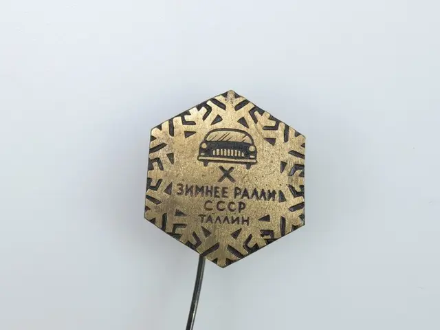 The image shows a gold pin with a black and white image of a car on it, set against a white...