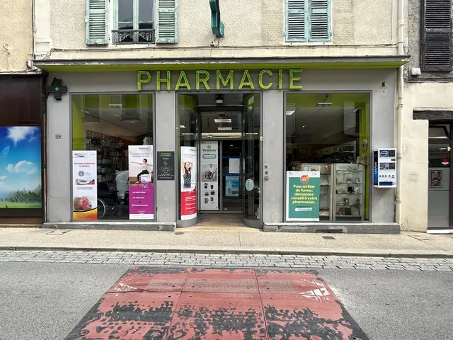 The image shows a pharmacy on the corner of a street, with glass walls and doors, posters on the...