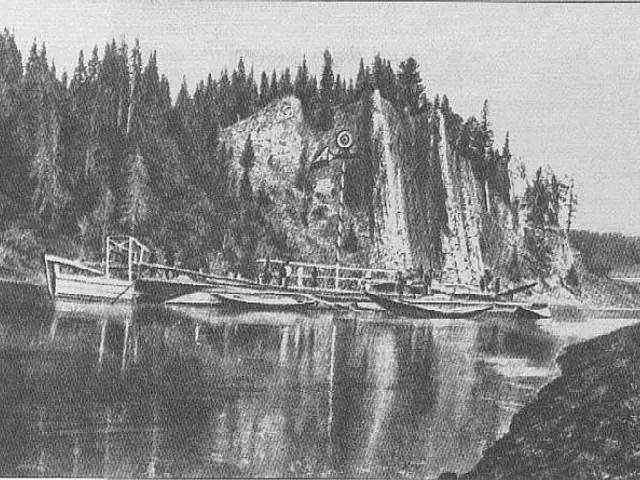 The image shows a black and white drawing of a boat docked in the water near a rocky shoreline,...
