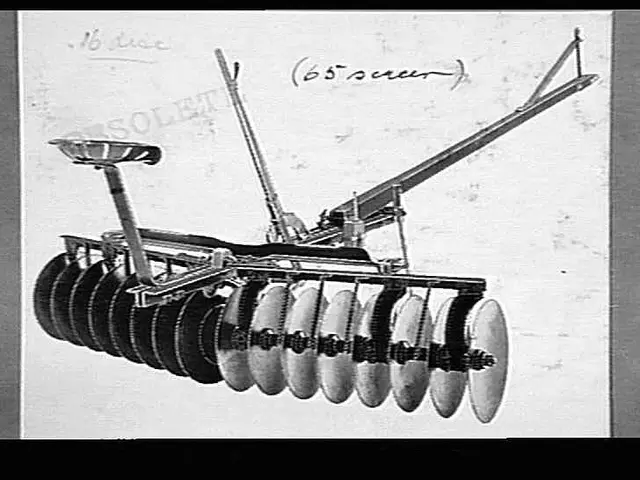 The image shows a black and white photo of a tractor with a disc harrow attached to it. The text...