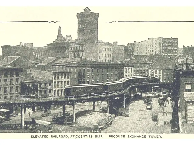 The image shows an old black and white photo of a city street with a train on the elevated railway...