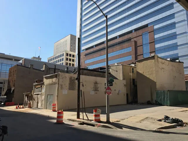 The image shows a city street with a bicycle parked on the side of it, surrounded by buildings,...
